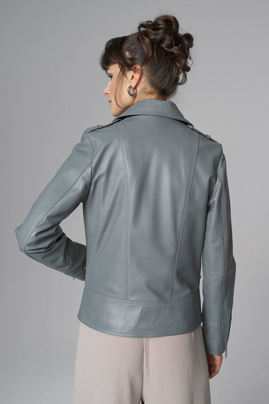 Woman wearing a gray leather jacket against a gray background
