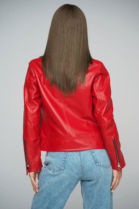 Person wearing a red leather jacket and blue jeans on a gray background