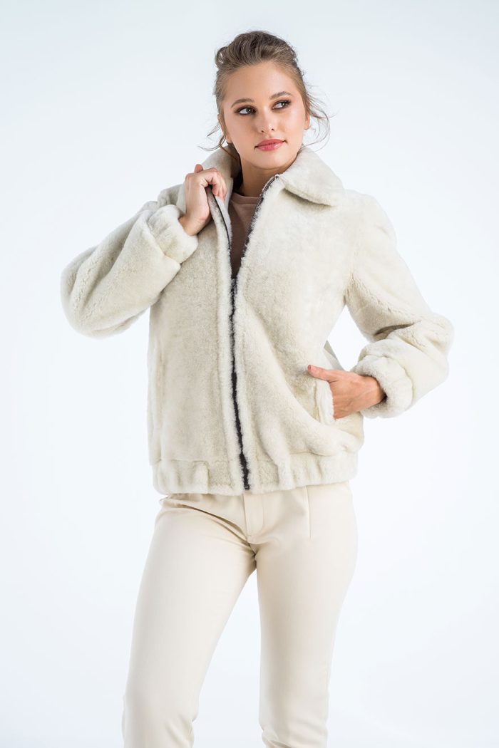 Woman wearing a cream-colored fleece jacket and pants on a white background