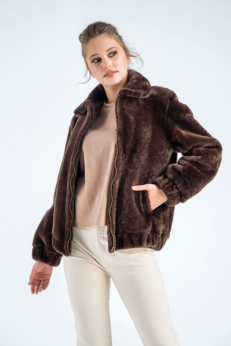Woman wearing a brown fur jacket on a white background
