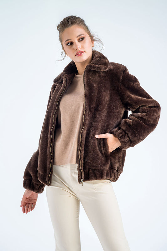 Woman wearing a brown fur jacket on a white background