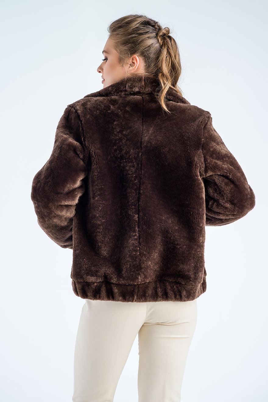 Person wearing a brown fur jacket on a white background