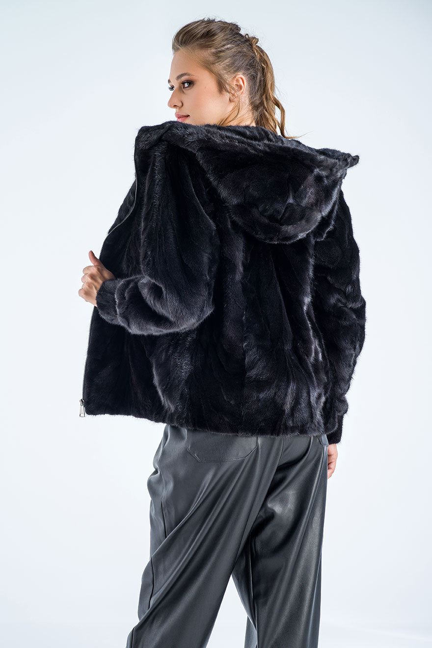 Person wearing a black fur jacket on a white background