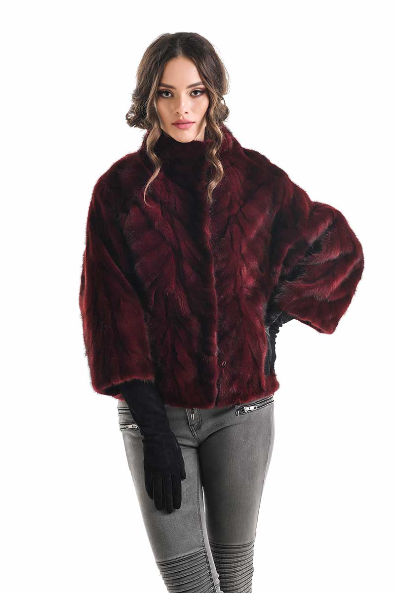 Woman wearing a burgundy faux fur jacket on a white background