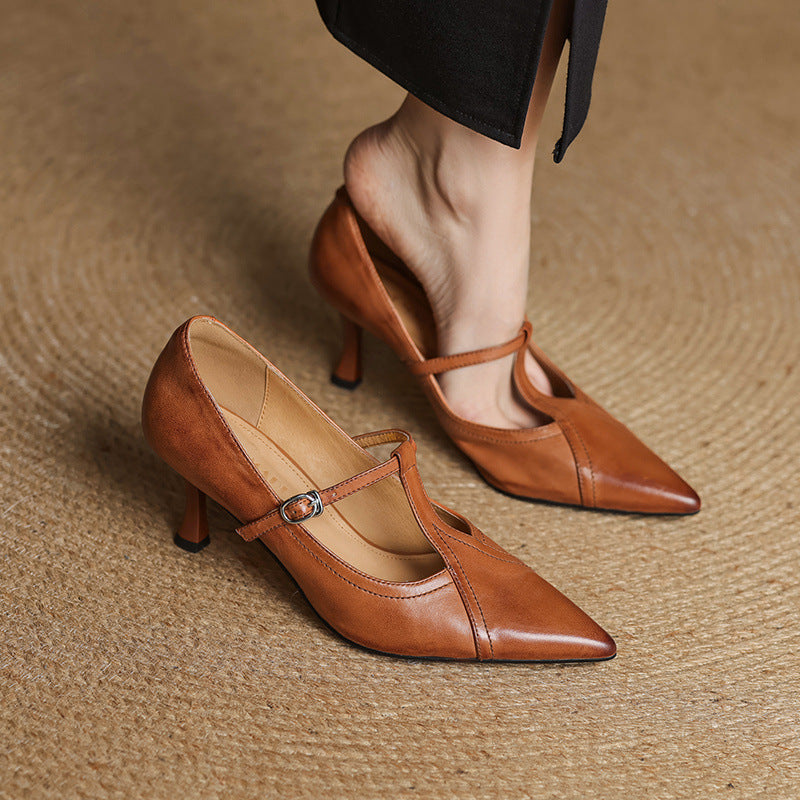 Brown high-heeled shoes with a strap on a textured surface