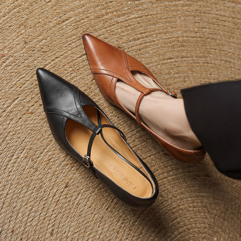 Black and brown pointed-toe flats on a textured surface