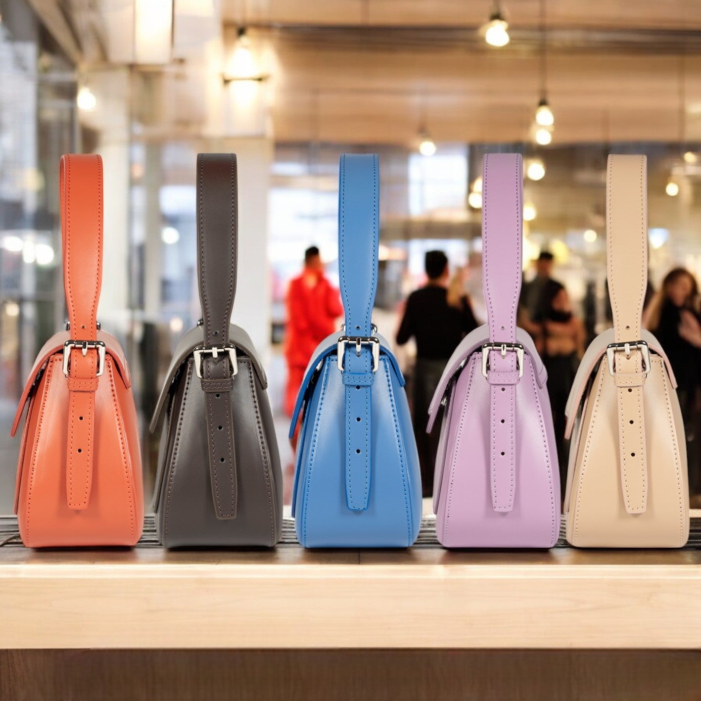 Five colorful handbags on a wooden surface with a blurred indoor background.
