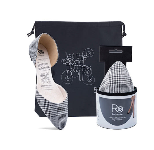 Plaid flat shoe with packaging and a branded container on a white background