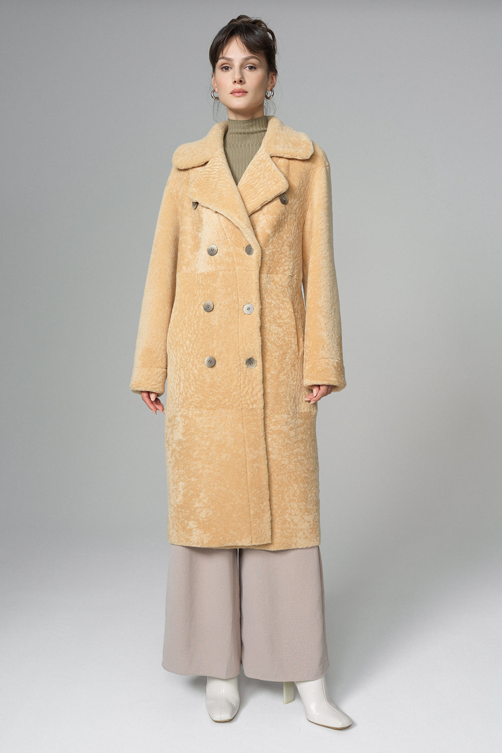 Person wearing a beige coat on a gray background