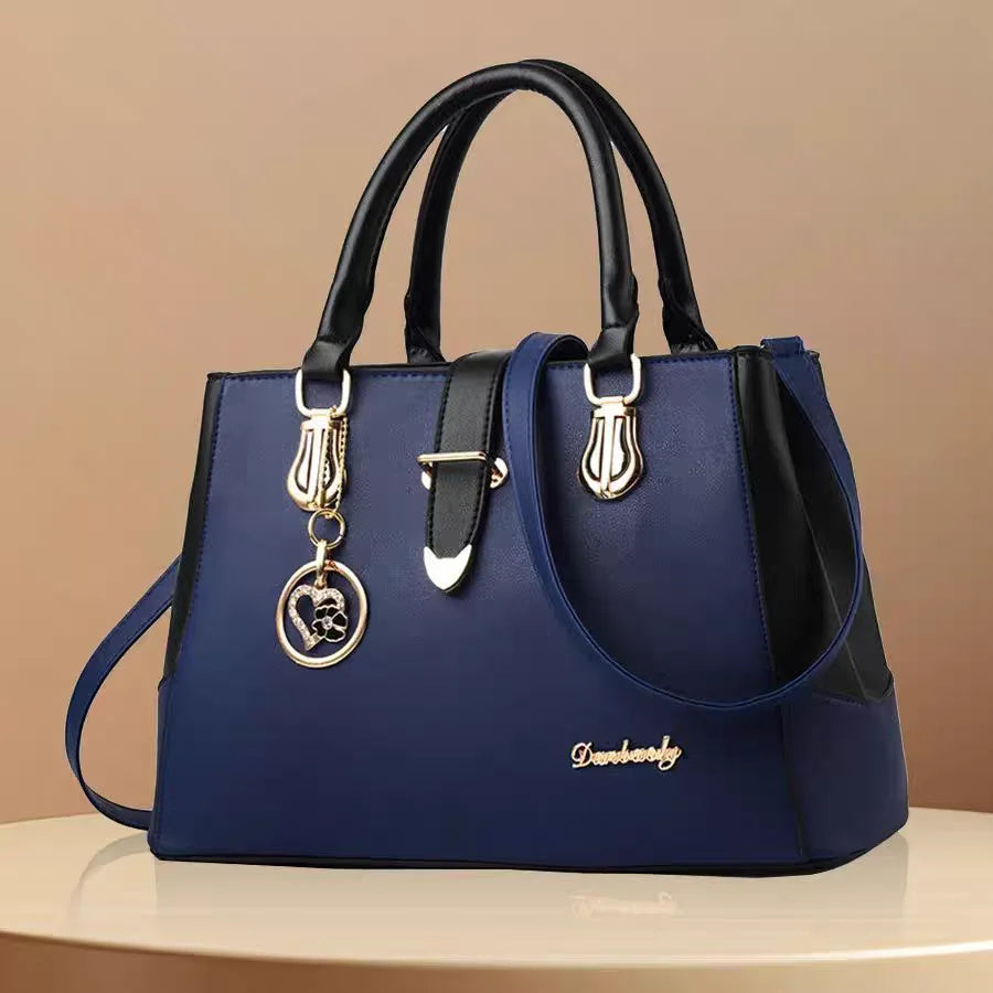 Blue handbag with black accents and a gold clasp on a beige background