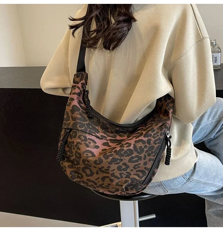 Person wearing a leopard print bag over one shoulder indoors.