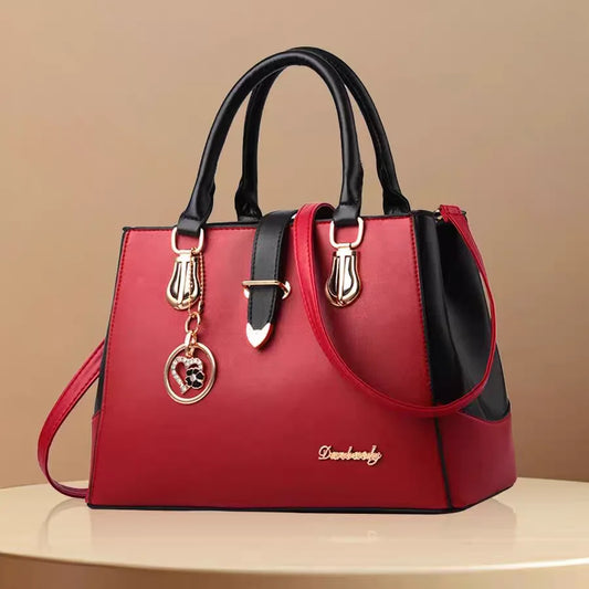 Red handbag with black accents on a beige background