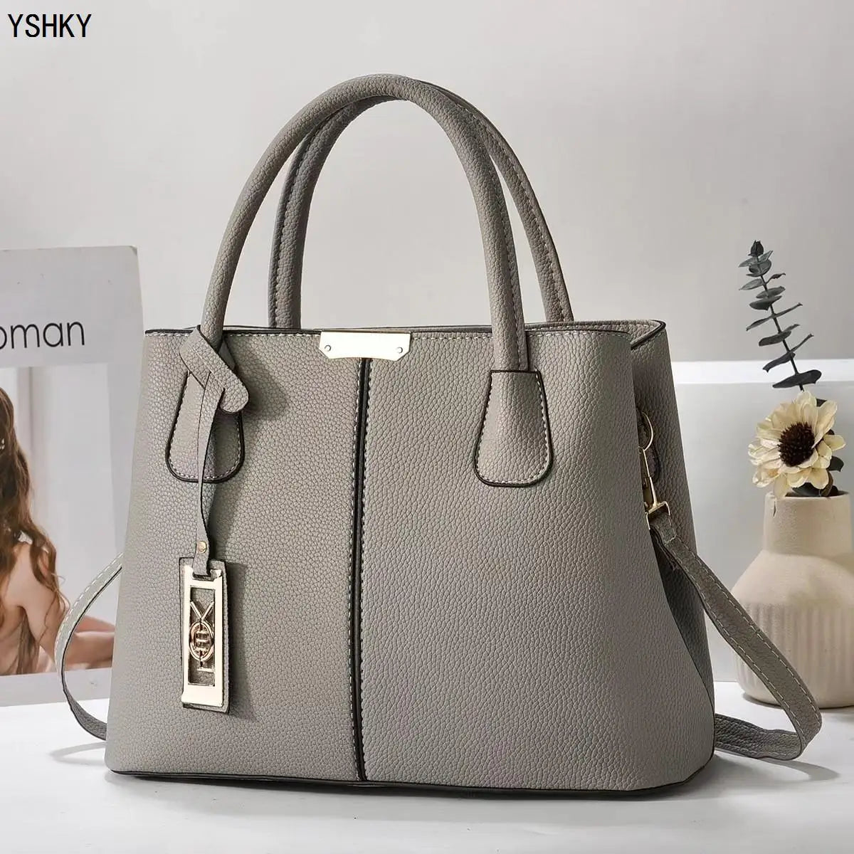 Gray handbag with a visible brand logo on a light background