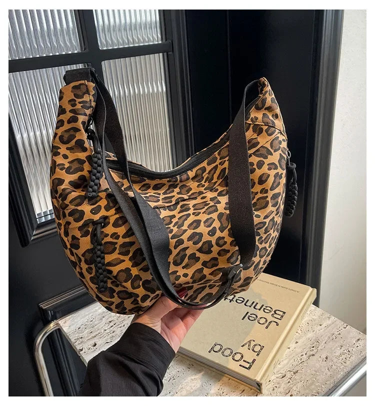 Leopard print bag held by a person with a book titled 'Food by Jenny' in the background.