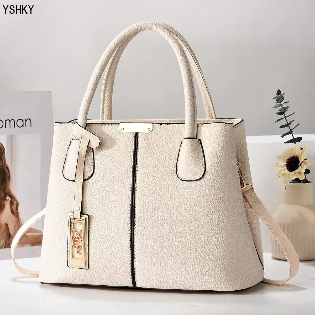 Beige handbag with a visible brand tag on a light background