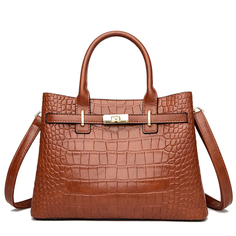 Brown crocodile-patterned handbag with a shoulder strap on a white background