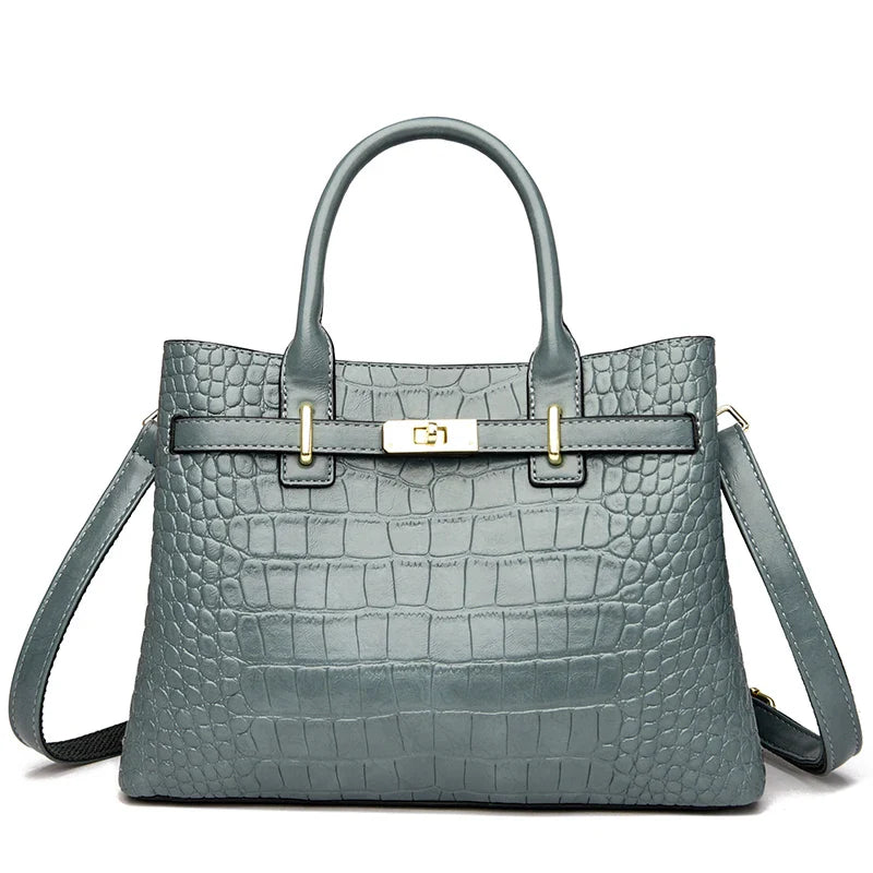 Green crocodile-patterned handbag with gold hardware on a white background