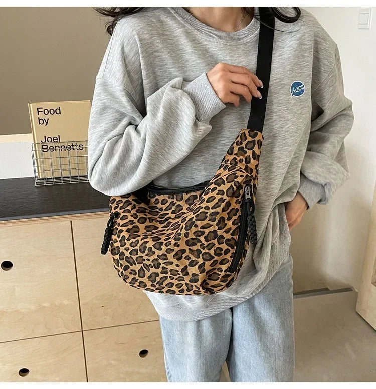 Person wearing a gray sweatshirt with a leopard print bag