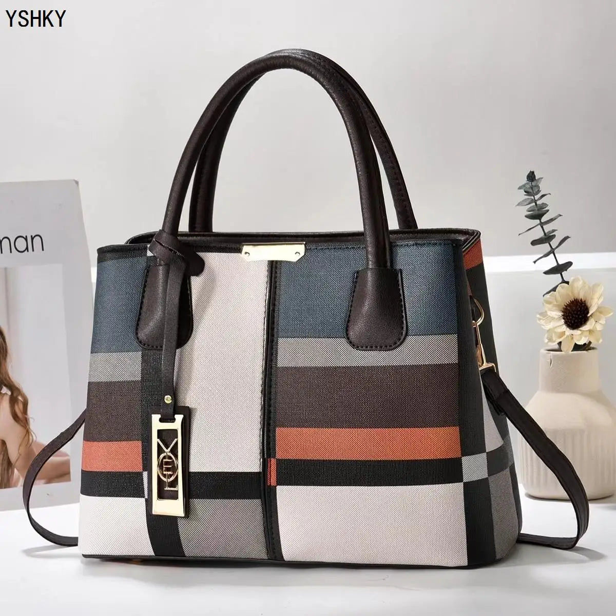 Multicolored striped handbag with a visible brand logo on a light background
