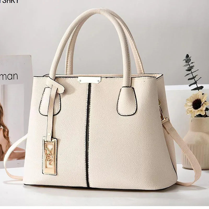 Beige handbag with a visible brand tag on a light background