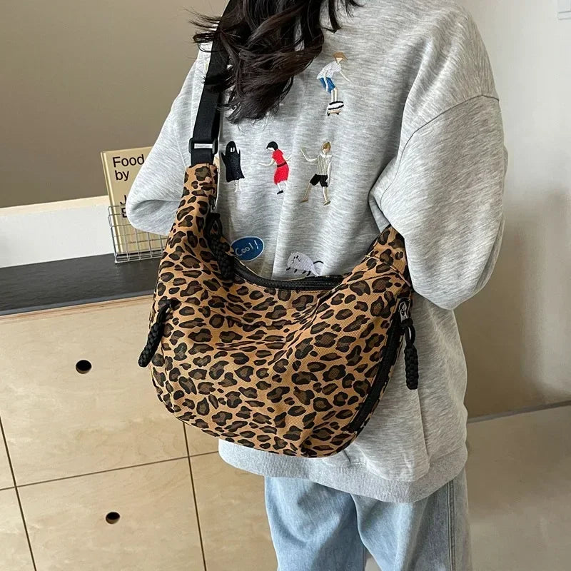 Person wearing a gray sweatshirt with a leopard print bag