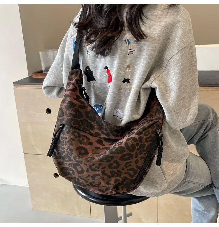 Person wearing a leopard print bag in an indoor setting
