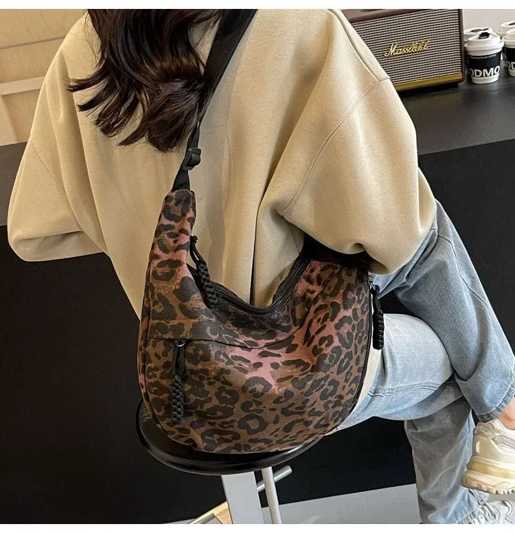 Person wearing a leopard print bag in an indoor setting