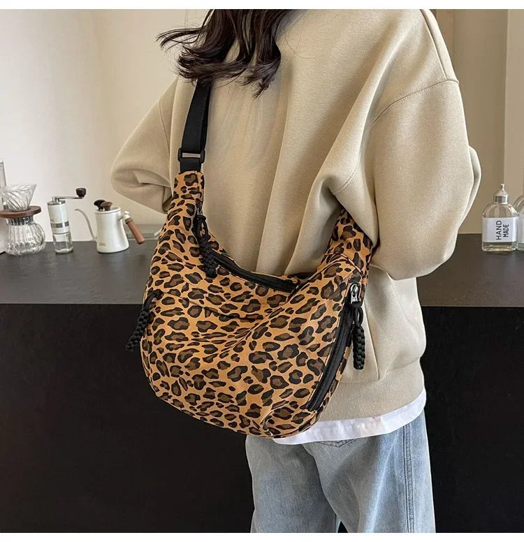 Person wearing a leopard print bag in an indoor setting