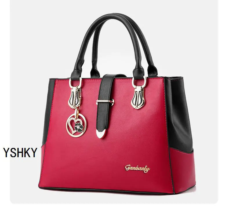 Red handbag with black accents and a keychain on a white background, featuring the brand 'YSHKY'.