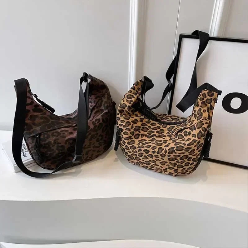 Two leopard print bags on a white surface with a blurred background