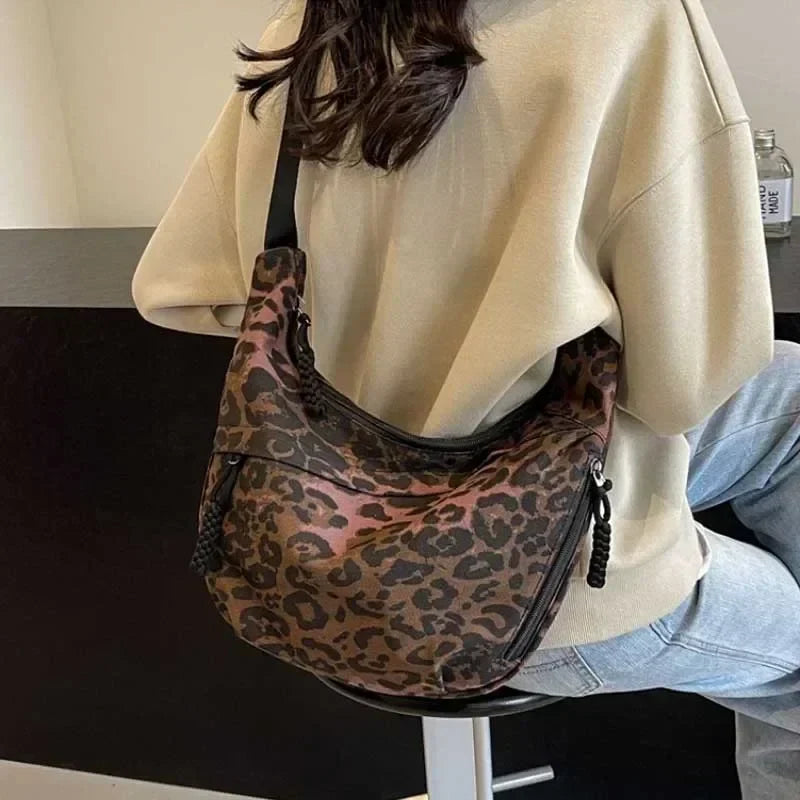 Person wearing a beige sweater with a leopard print bag over their shoulder.