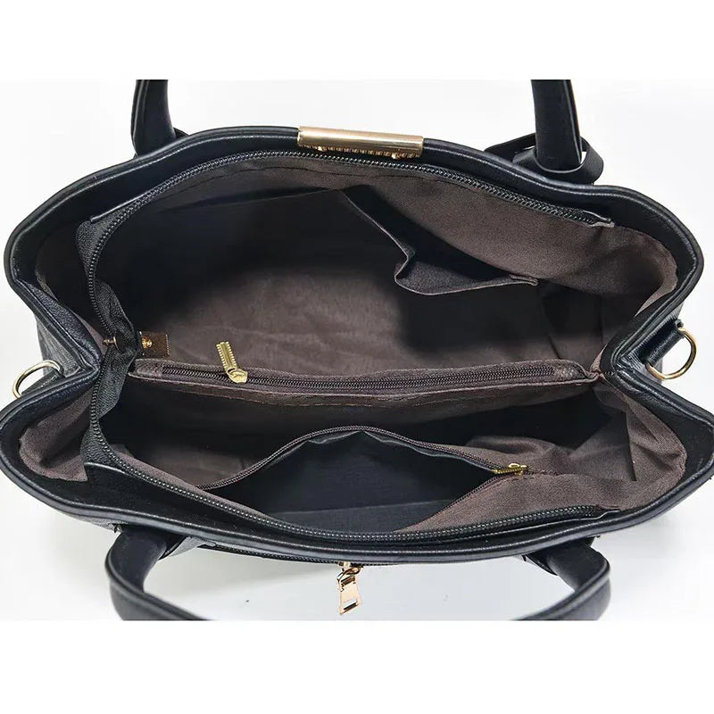 Black handbag with gold zippers on a white background