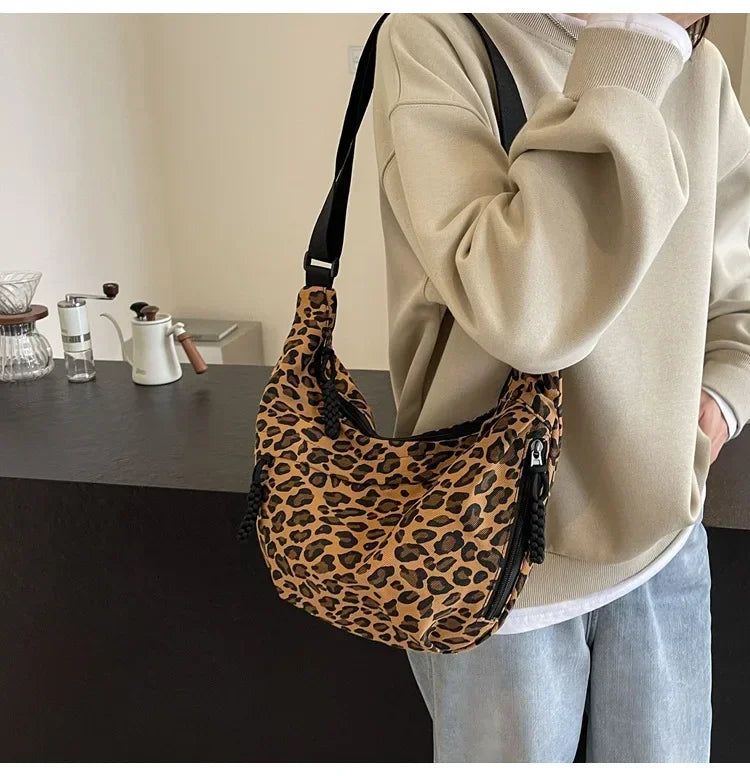 Person holding a leopard print bag in an indoor setting