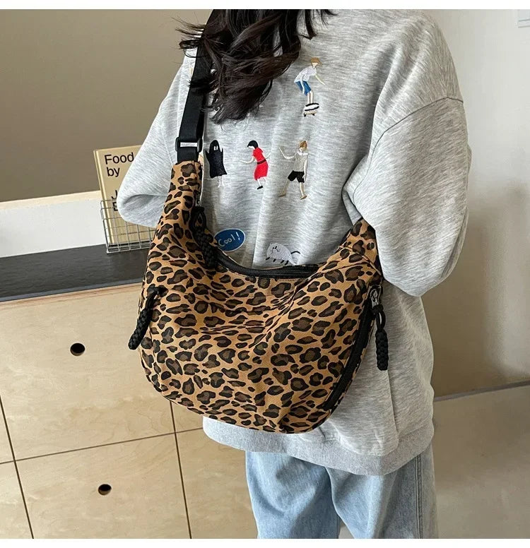 Person wearing a leopard print bag over one shoulder indoors.