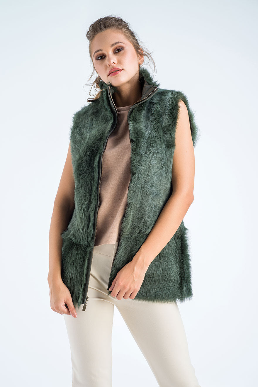 Woman wearing a green fur vest on a white background