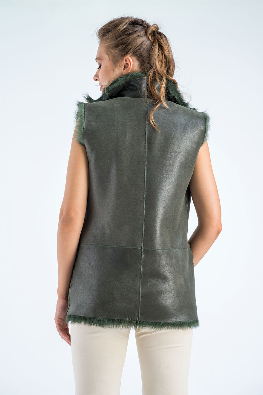 Woman wearing a green leather vest on a white background