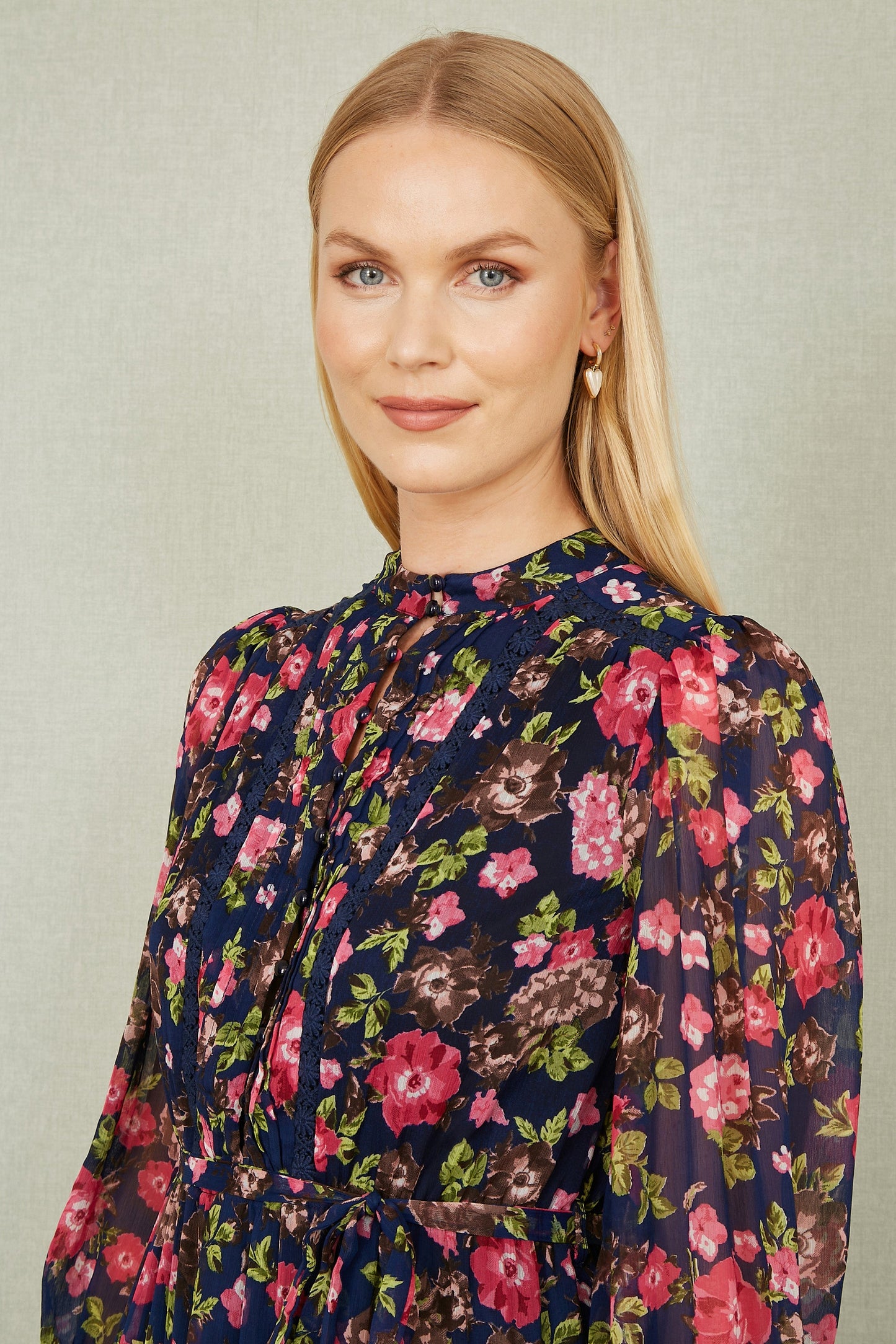 Woman wearing a floral blouse with a neutral background