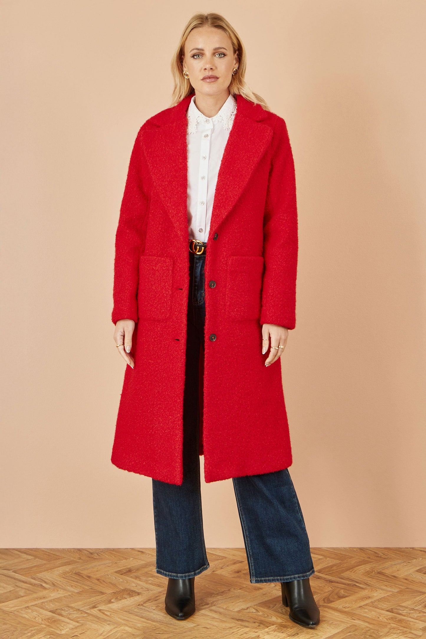 Person wearing a red coat with a plain background