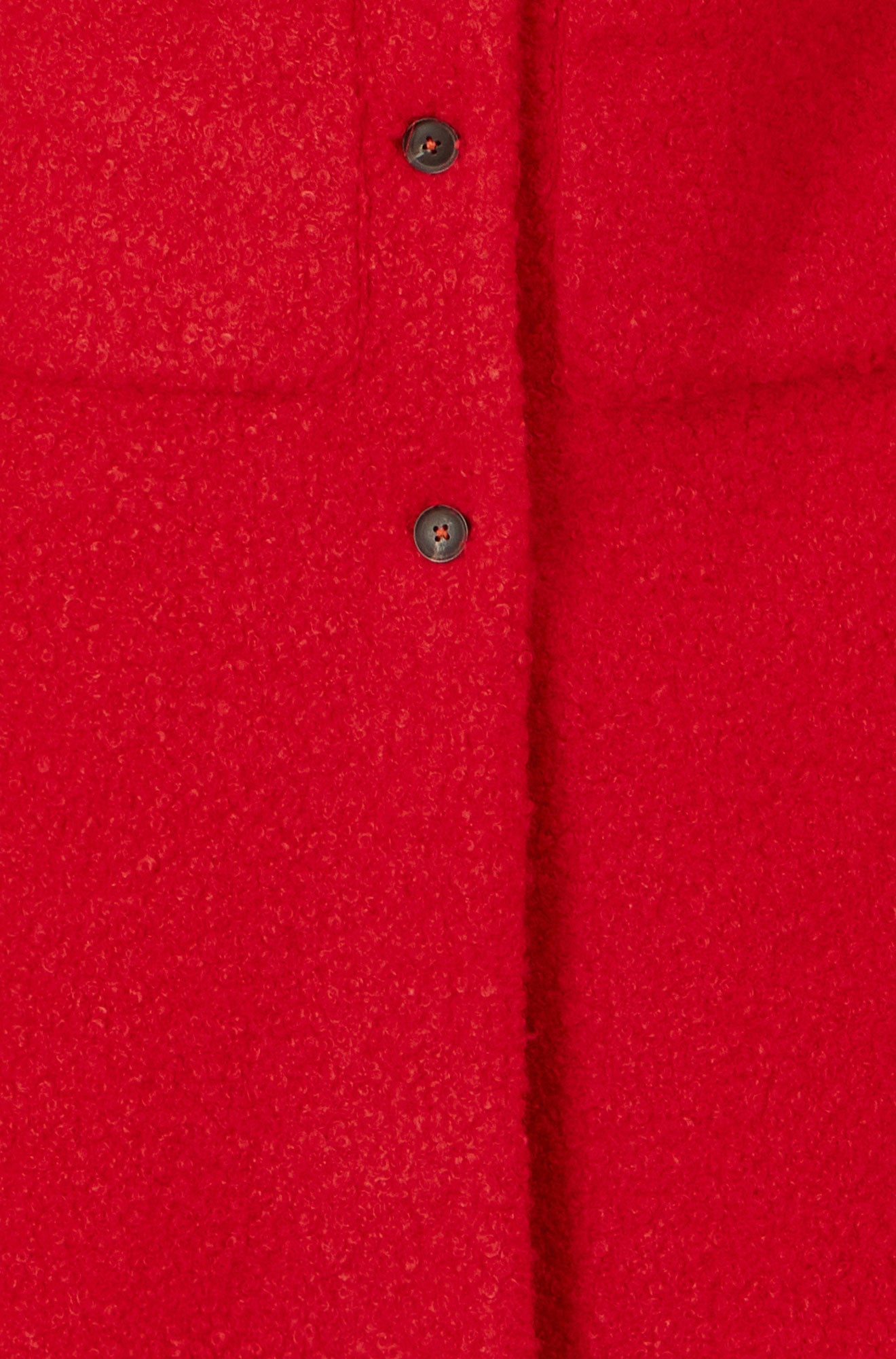 Close-up of a red textured fabric with buttons