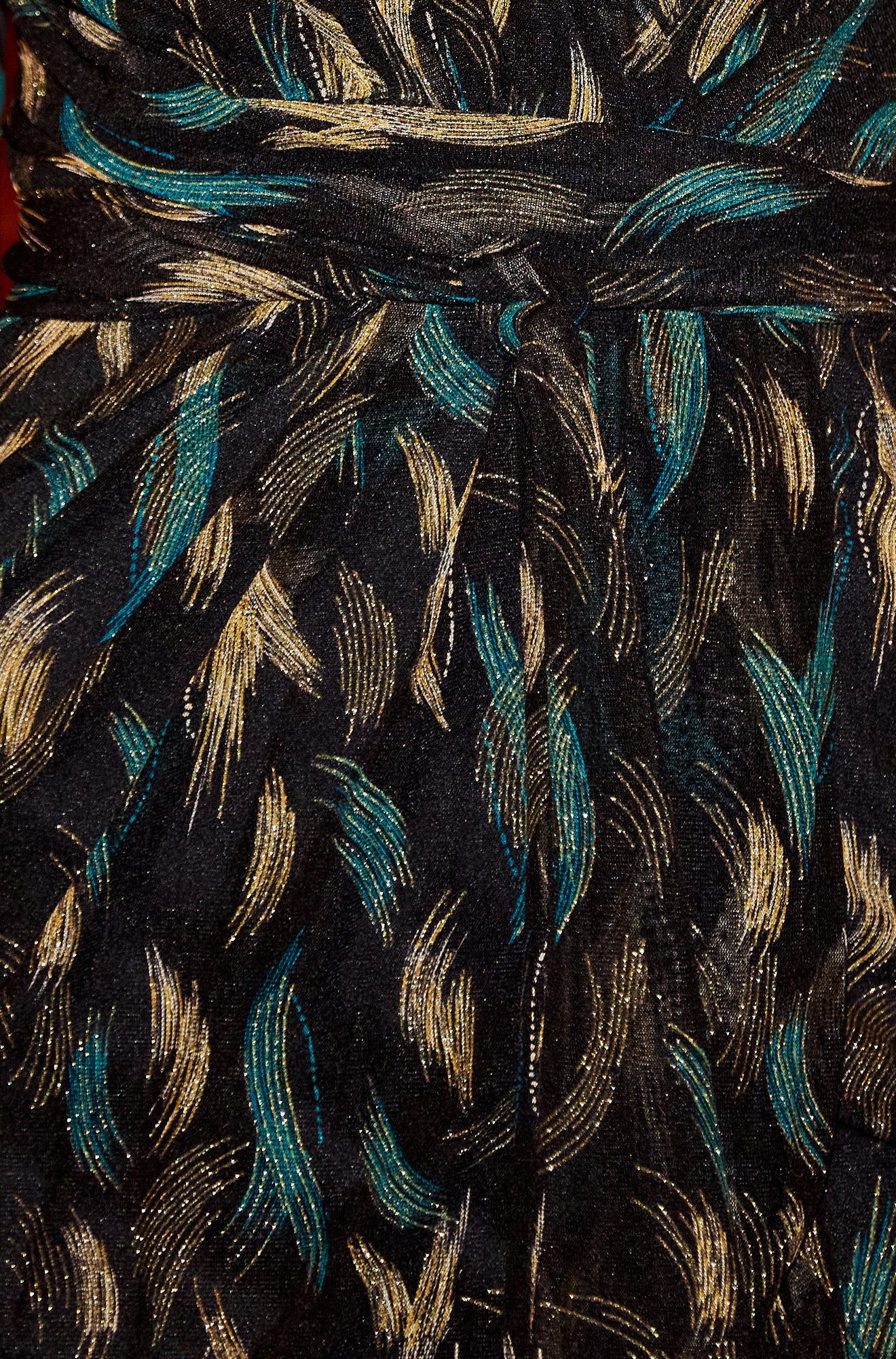 Close-up of a patterned fabric with blue and gold designs on a black background