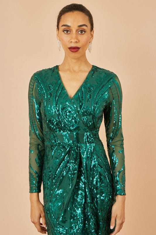 Woman wearing a green sequin dress against a beige background