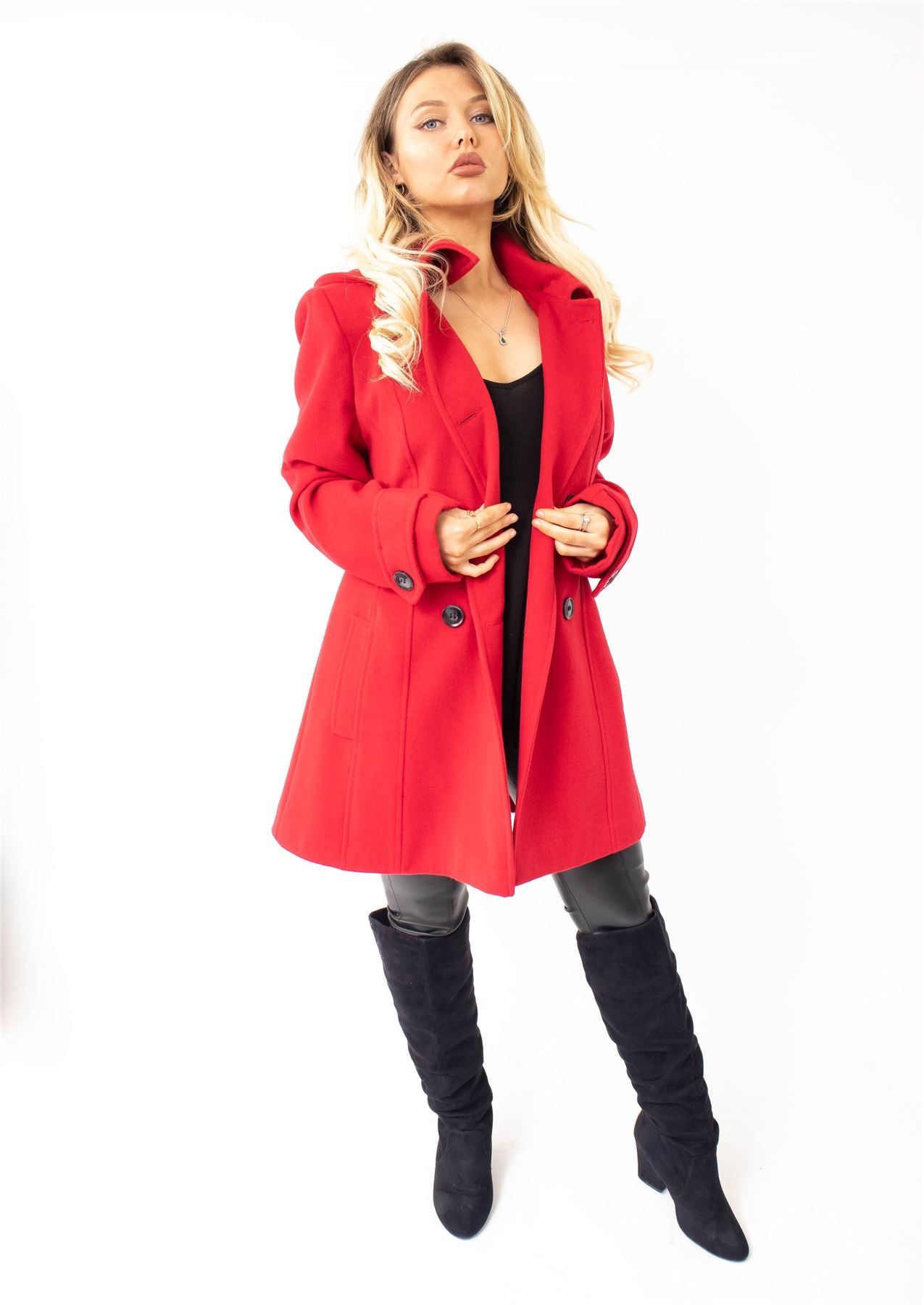 Woman wearing a red coat and black knee-high boots on a white background