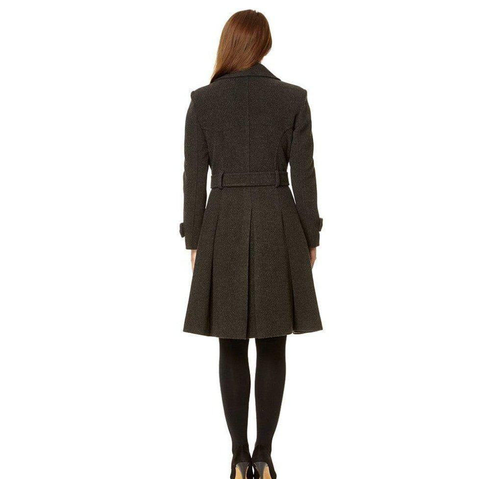 Woman wearing a long dark coat on a white background