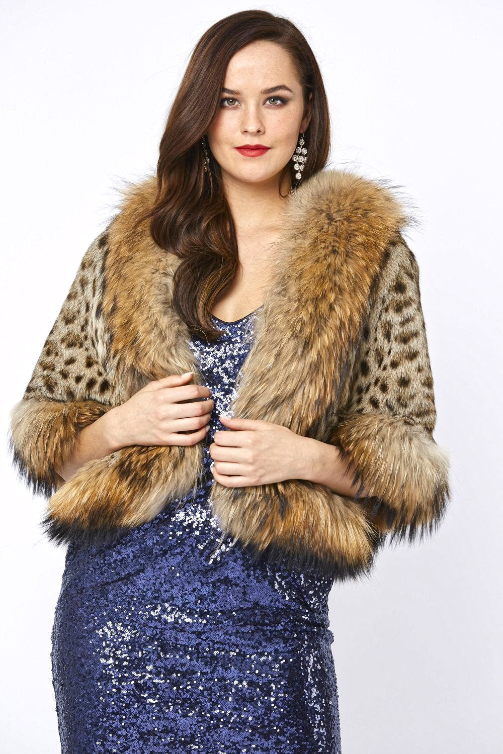 Woman wearing a blue sequin dress with a fur coat on a white background