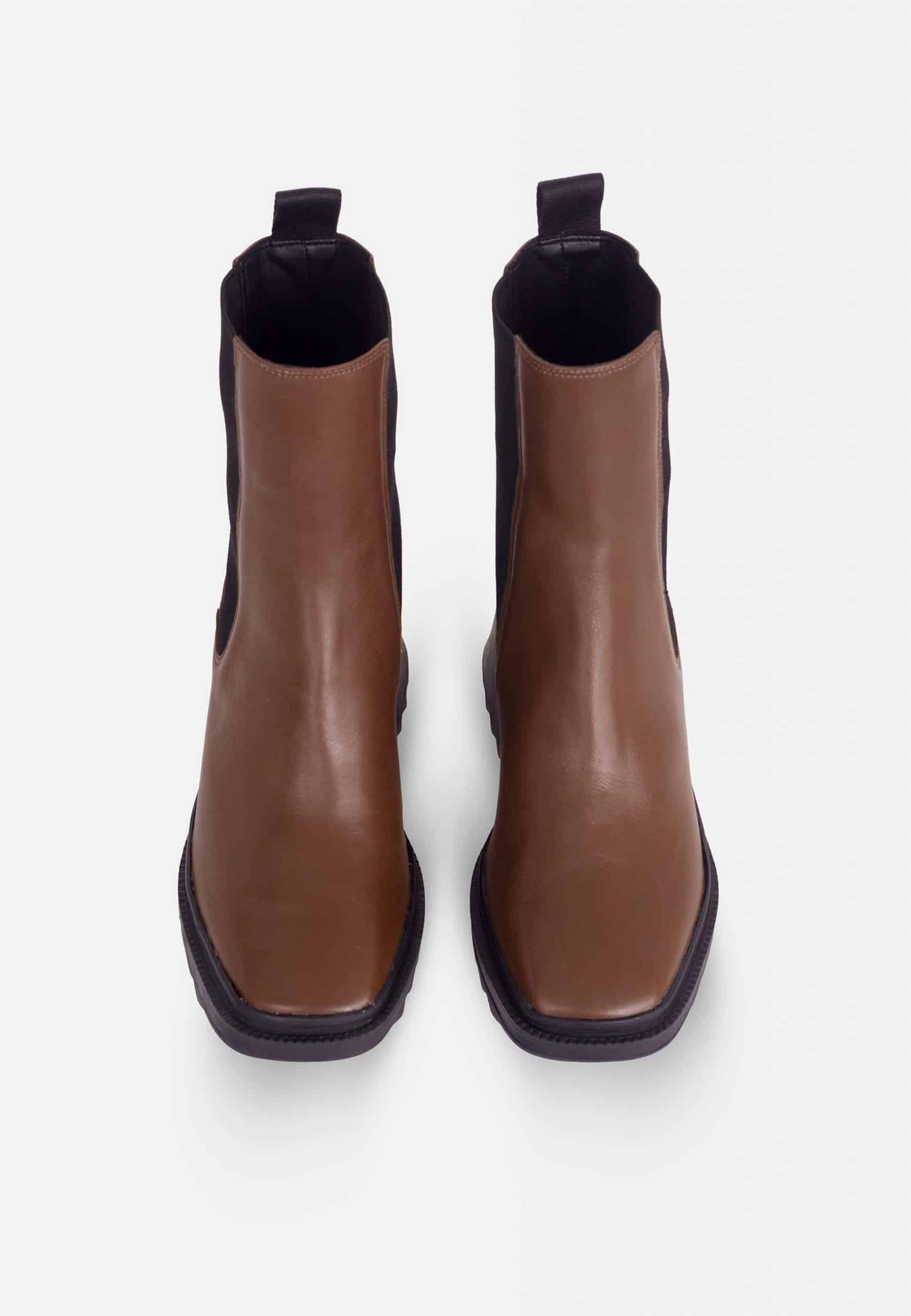 Pair of brown leather ankle boots on a white background
