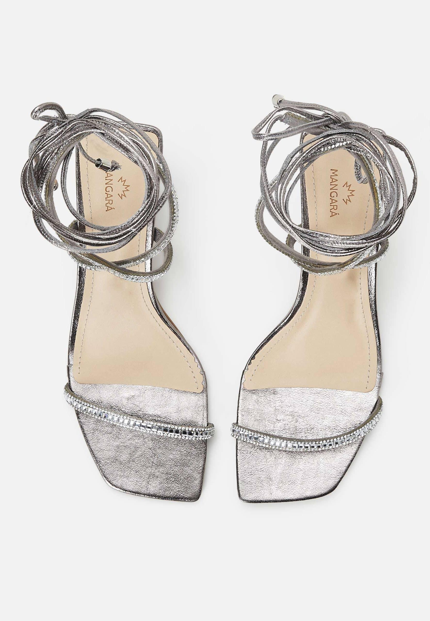 Pair of silver strappy sandals on a white background
