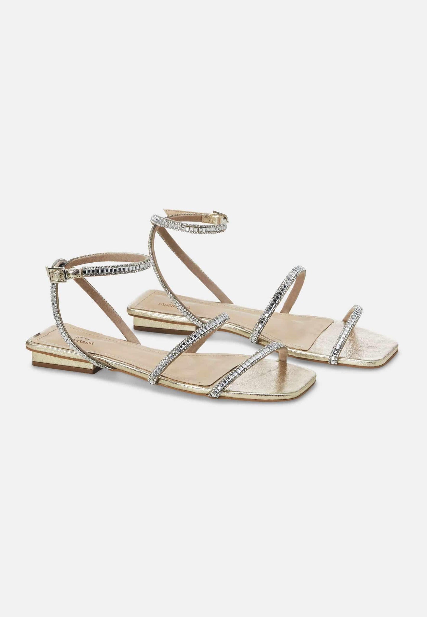 Pair of gold sandals with gemstone straps on a white background
