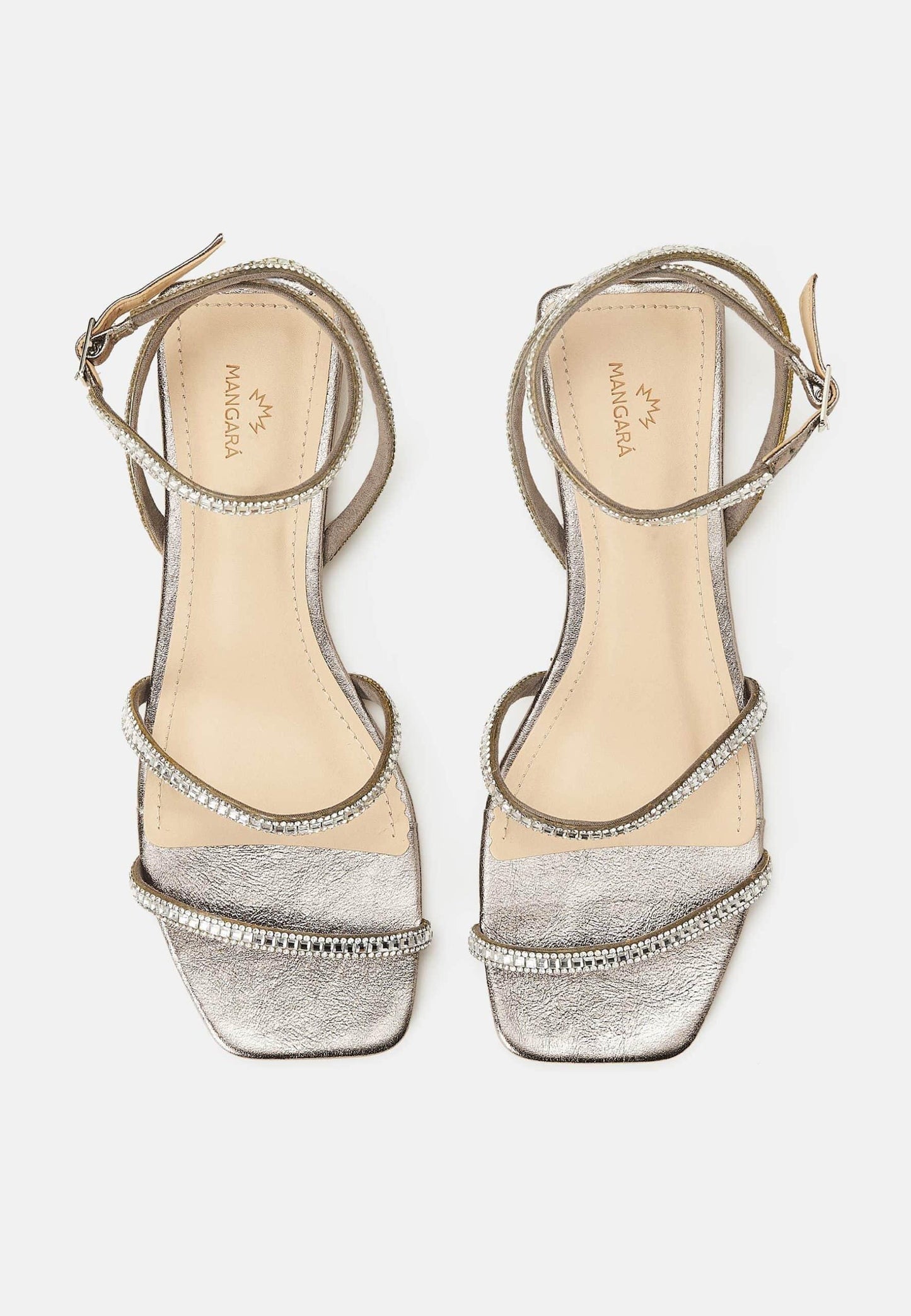 Pair of silver high-heeled sandals with decorative straps on a white background