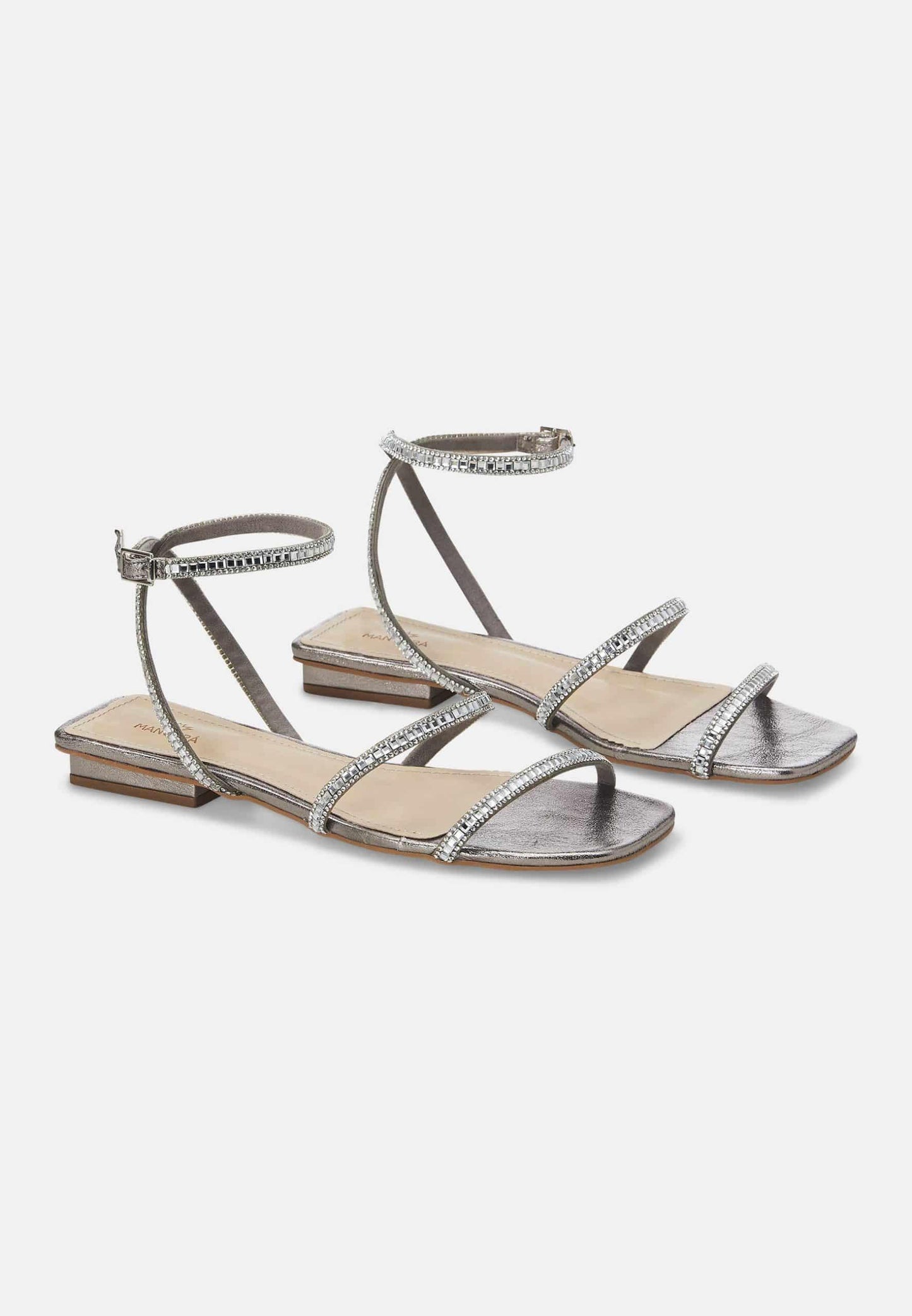Pair of silver strappy sandals on a white background