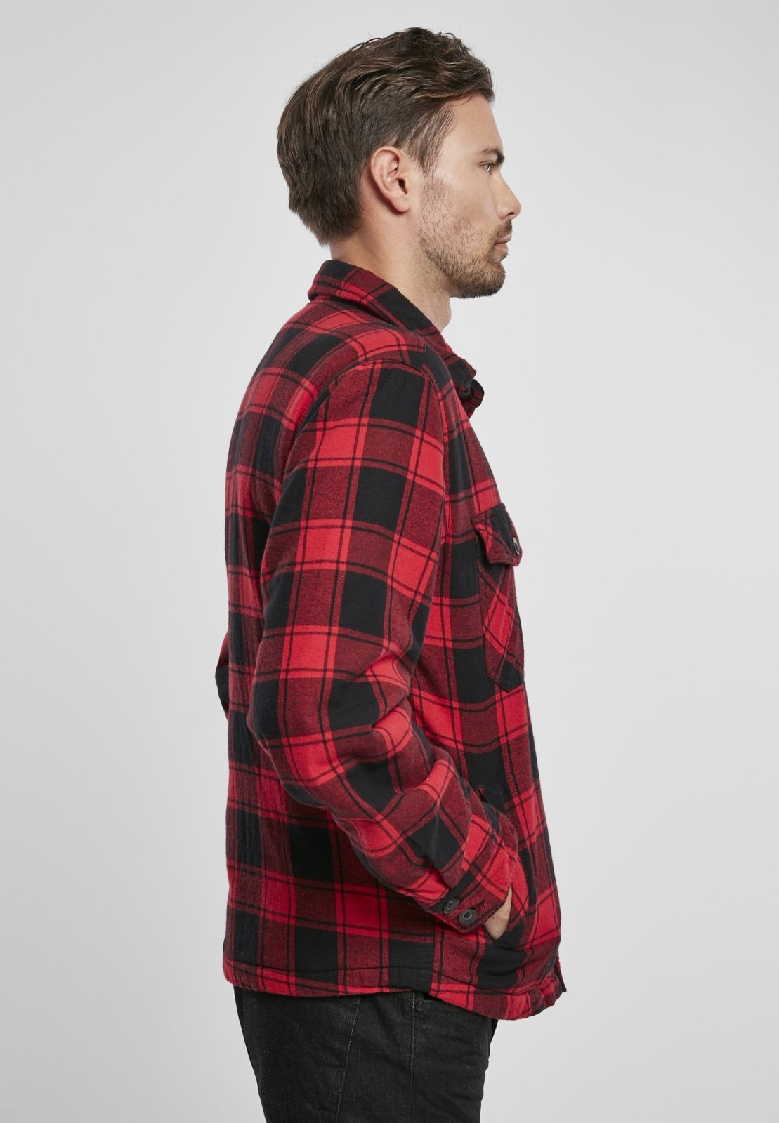 Man wearing a red and black plaid shirt against a white background